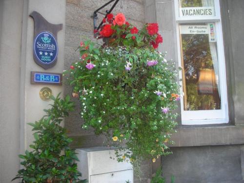 a hanging basket of flowers on the side of a building at Sonas Guesthouse in Edinburgh