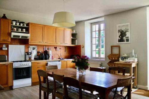 une cuisine avec une table en bois et une salle à manger dans l'établissement La Petite Maison, à Trégastel