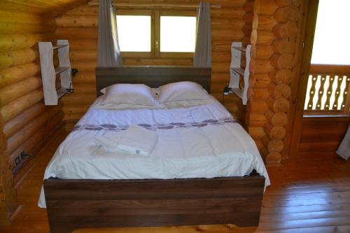 a bedroom with a bed in a log cabin at Chalet POMMAT in La Tania