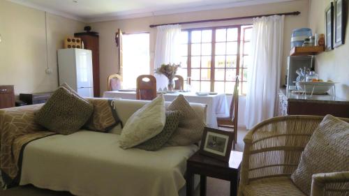 a living room with a couch with pillows on it at Old Inchgarth Farmstay in Himeville