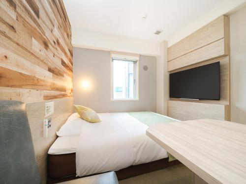 Un pat sau paturi într-o cameră la Super Hotel Sendai Hirose Dori