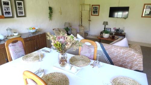 a table with a vase of flowers on it at Old Inchgarth Farmstay in Himeville