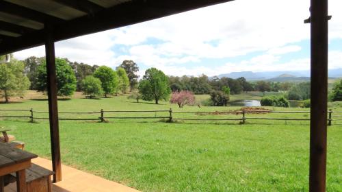 a view from a porch of a field with a fence at Old Inchgarth Farmstay in Himeville