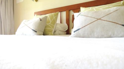 a bed with white sheets and pillows on it at Old Inchgarth Farmstay in Himeville