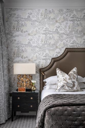 a bedroom with a bed and a wall covered in wallpaper at The Kensington Hotel in London
