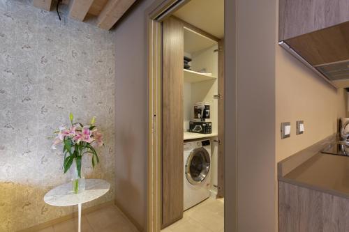 una lavandería con un jarrón de flores sobre una mesa en Residence 8 Loft en Venecia