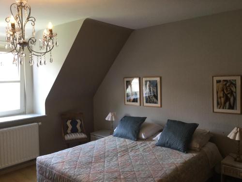 a bedroom with a bed with blue pillows at B&B Het Colettientje in Bruges