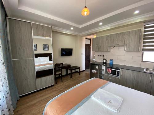 um quarto de hotel com uma cama, uma cozinha e um quarto em Hemak Suites em Nairobi