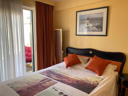 Un dormitorio con una cama con un cuadro en la pared. en ZEEPAREL Duplex loft, en Blankenberge