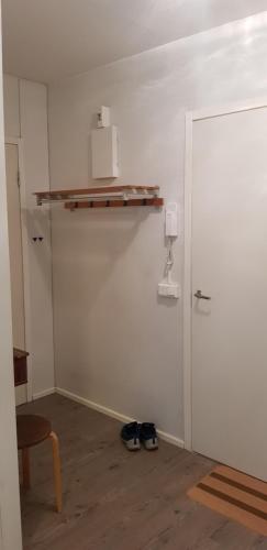 um quarto com uma parede branca com uma prateleira e uma porta em Studio near City - Puinnintie em Pori