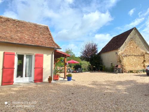 a house with red doors and a patio at Les chambres de Beauviel in Saint-Jean-dʼEyraud