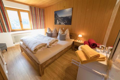 sypialnia z łóżkiem i umywalką w obiekcie Gästehaus Laurin w mieście St. Gallenkirch