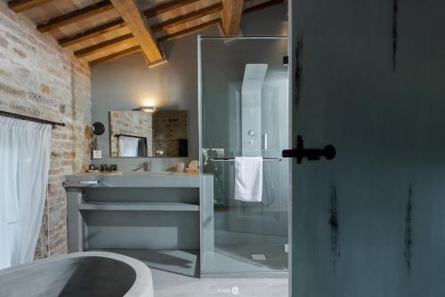 La salle de bains est pourvue d'une douche en verre et d'un lavabo. dans l'établissement Villa Anitori Prestige Relais & Spa, à Loro Piceno