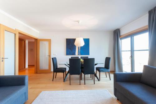 a living room with a dining room table and chairs at Your Lisbon Home Parque das Nações in Lisbon