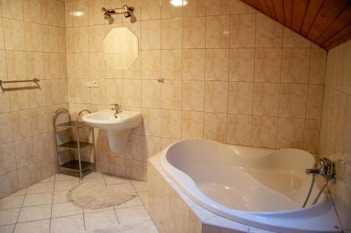 ein Badezimmer mit einer Badewanne und einem Waschbecken in der Unterkunft Apartmany Harrachov in Harrachov