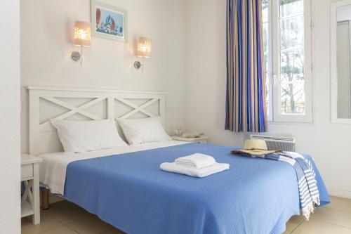 - une chambre avec un lit bleu et des serviettes dans l'établissement Résidence Odalys Terre Marine, à Saint-Pierre-dʼOléron