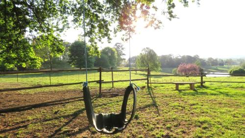 a swing in a park with a bench at Old Inchgarth Farmstay in Himeville