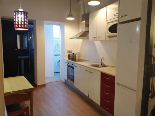 a kitchen with white cabinets and a sink at Apartamento Gutenberg in Valencia