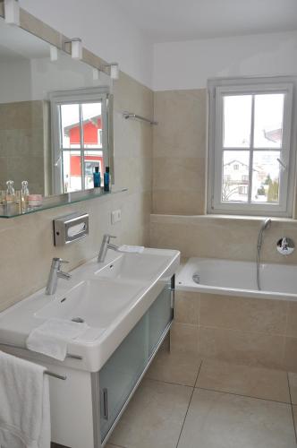a bathroom with a sink and a tub and a mirror at Avenida Mountain Resort A11 in Kaprun