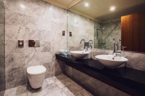 a bathroom with two sinks and a toilet at The Victoria Hotel in Galway