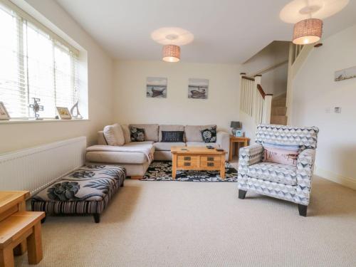 a living room with a couch and a chair at 26 Burtons Mill in Norwich