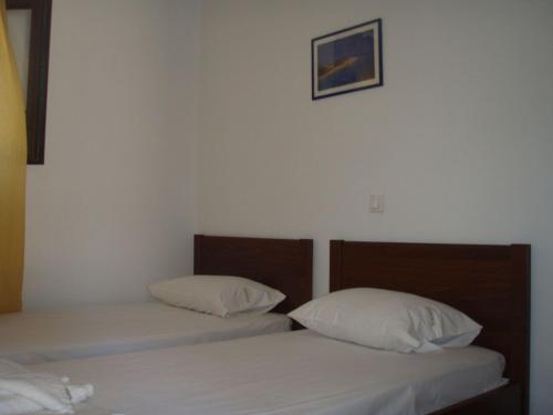 two beds in a room with white sheets and pillows at Wonderful Skiathos Villa Two Bedroom Villa Parisis Short Walk to Beachl Troulos in Troulos