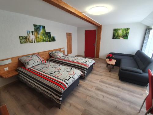 een woonkamer met 2 bedden en een bank bij Gasthof Schwanen Radelfingen in Radelfingen
