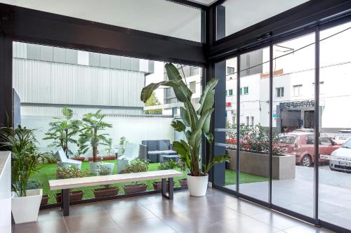 a room with a bench and potted plants at Hotel BESTPRICE Alcalá in Madrid