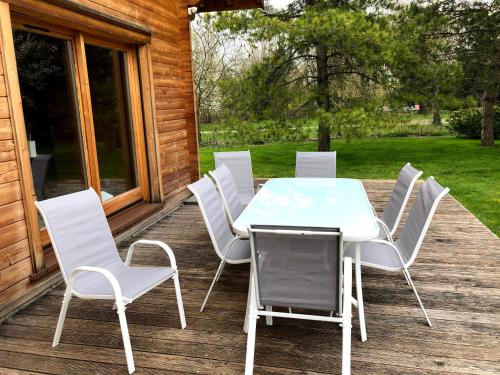 a white table and chairs on a deck at Gîte Autre Ruche in Baudement