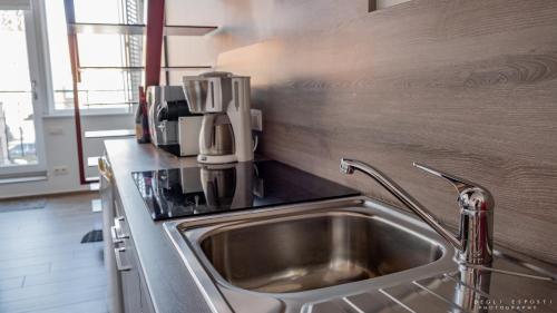uma cozinha com um lavatório e comodidades para preparar café no balcão em Gîte Citadin Athois em Ath