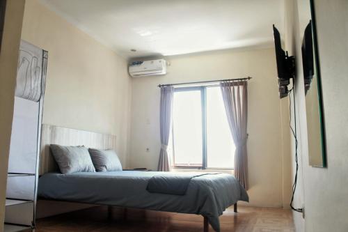 a bedroom with a bed in front of a window at bumimakhraja syariah 4 in Bandung