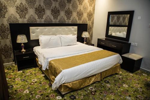 Zahrat Rozah By Quiet Rooms في الرياض: غرفة نوم بسرير كبير وموقف ليلتين