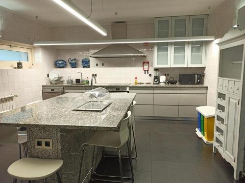 a kitchen with a counter and stools in it at Casa do Passal Country House in Paço de Sousa