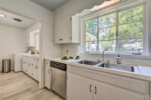 a white kitchen with a sink and a window at Ocean Springs Home - Walk to Beach and Downtown! in Ocean Springs