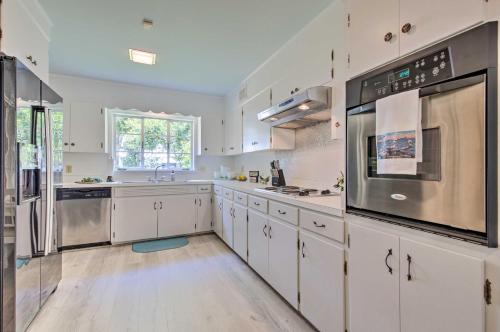 a large kitchen with white cabinets and stainless steel appliances at Ocean Springs Home - Walk to Beach and Downtown! in Ocean Springs