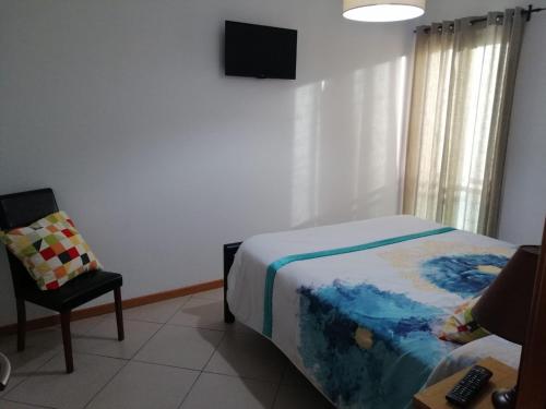 una camera con letto, sedia e televisore di Vilas Horizonte a Porto Santo
