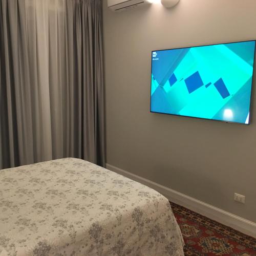 a room with a bed and a flat screen tv on a wall at SAN FRANCESCO Apartment in Turin