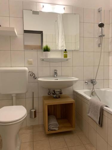 a bathroom with a sink and a toilet and a tub at Goisererglück in Bad Goisern