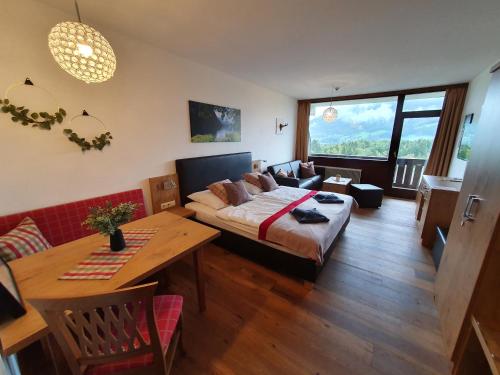 ein Schlafzimmer mit einem Bett, einem Tisch und einem Sofa in der Unterkunft Goisererglück in Bad Goisern