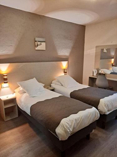 a hotel room with two beds and two lamps at Hôtel Du Viaduc in Tarascon