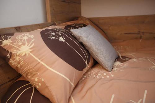 a bed with two pillows on top of it at Apartma Natura Kope in Šmartno pri Slovenj Gradcu