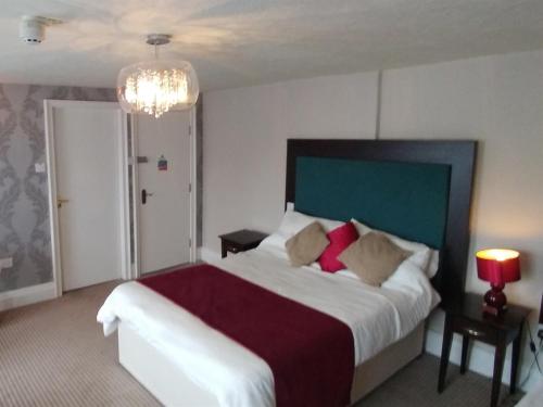 a bedroom with a large bed and a chandelier at The Engine Inn in Holker