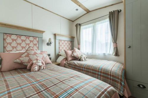a bedroom with two beds with a teddy bear on top of them at The Warren in South Cerney