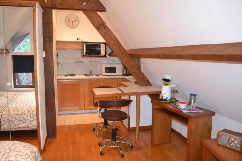 a small kitchen with a desk and a bed in a room at Studio du Domaine de la Petitière in Bonneville-la-Louvet