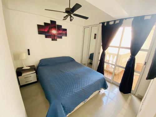 um quarto com uma cama azul e uma janela em Departamento moderno pleno centro salta capital em Salta