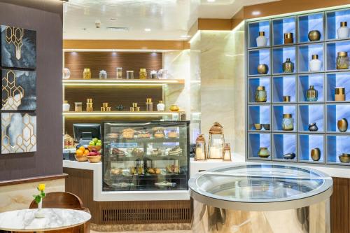 a bakery with a display case with food in it at Al Marwa Rayhaan by Rotana - Makkah in Makkah