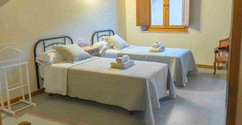 a room with two beds with towels on them at Casa Rural Bonal in La Mata de los Olmos