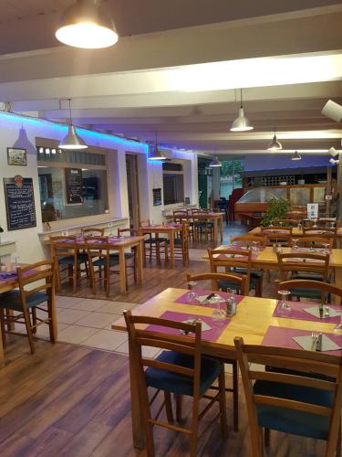 a restaurant with wooden tables and wooden chairs at LE SPORTING in Beaumont-sur-Lèze