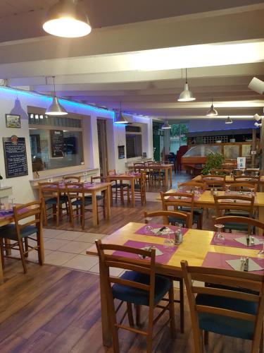 un ristorante con tavoli e sedie in legno di LE SPORTING a Beaumont-sur-Lèze