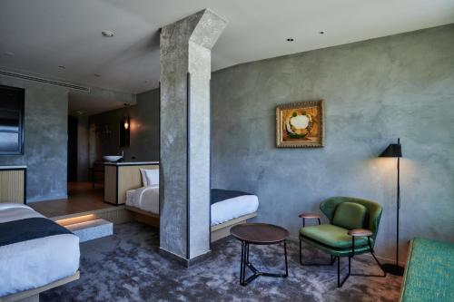 a hotel room with two beds and a chair at The Tower Hotel Nagoya in Nagoya